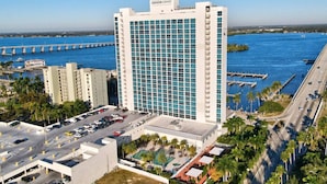Ein Hochhaus-Hotel mit Blick auf eine Marina, mehreren Parkebenen und einem Poolbereich.