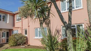 A two-story building with a garden in front. - Devon Seaside Apartment (Paignton)