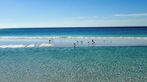 Una platja amb aigua turquesa cristal·lina i un tram de sorra.