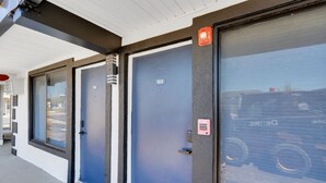 Een gebouw met drie blauwe deuren, elk voorzien van een nummer.