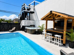 A swimming pool with a hot tub, outdoor seating, and a pergola. - Pool Access, Free Parking | Jersey Shore Stay (Seaside Heights)