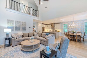 A spacious living area with a sofa, coffee table, and dining table. - Luxury Dunes Paradise - Private Pool (Hilton Head Island)