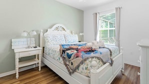 A bedroom with a bed, nightstand, and window with blinds. - Wishes Villa Pool & Hot Tub (Kissimmee)