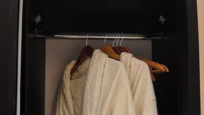 A closet with two white bathrobes hanging on wooden hangers. - Perfect studio with AC in charming 6 October city (6 October)