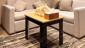 A modern living room with a sofa, a small table with a box, and a patterned rug. - Perfect studio with AC in charming 6 October city (6 October)