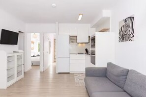 A modern apartment with a kitchen, living room, and a hallway leading to a bedroom. - Nuria Cala Blanca (Cala Blanca)