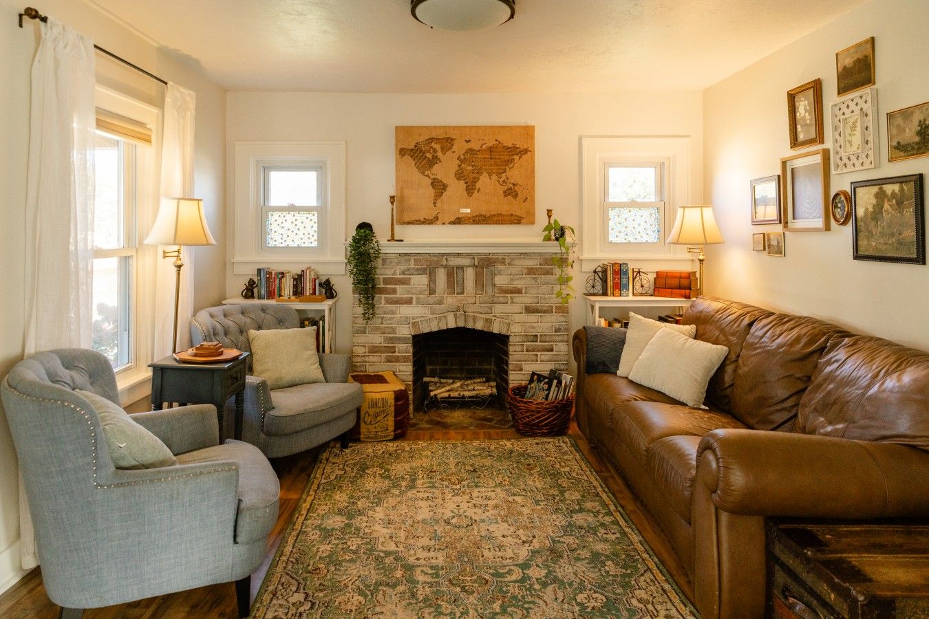 A cozy living room with a fireplace, two armchairs, a sofa, and a patterned rug.