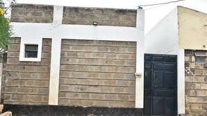 A building with a brick facade, a white upper section, and a black door. - AJ Urban Escape (Nairobi)
