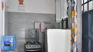 A compact kitchen with a gas stove, oven, and a water dispenser. - AJ Urban Escape (Nairobi)