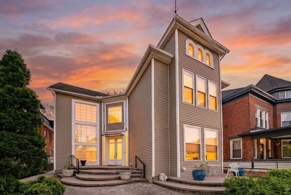 A two-story house with a prominent gable roof, large windows, and a well-maintained front porch.