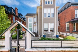 A residential building with a prominent central tower, a gated entrance, and a small patio area with outdoor seating.
