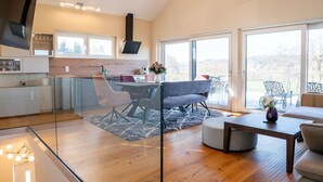 A modern kitchen with a dining area, large windows, and a view of the outdoors. - Apartment Near Graz With Sauna (Premstätten bei Vasoldsberg)
