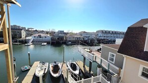 A waterfront property with docked boats, a pier, and residential buildings in the background. - Dockside Den,  Waterside 3BR, Close to All (Atlantic City)