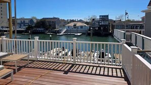 A wooden deck with white railings overlooking a marina with boats and docked yachts. - Dockside Den,  Waterside 3BR, Close to All (Atlantic City)