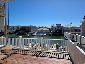 A wooden deck with white railings overlooking a marina with boats and docked yachts. - Dockside Den,  Waterside 3BR, Close to All (Atlantic City)
