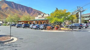 A parking lot with cars, a building with a clock, and a mountain in the background. - Charming Studio with Mtn.Views,Walk to Dwntwn (Carbondale)