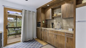 A compact kitchen with wooden cabinets, a built-in microwave, and a stainless steel sink. - Charming Studio with Mtn.Views,Walk to Dwntwn (Carbondale)