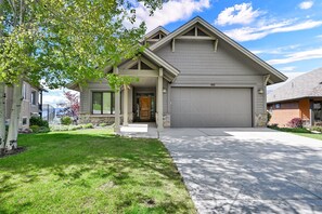 A modern two-story house with a covered front porch, a garage, and a well-maintained lawn.
