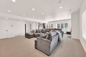 A spacious living room with a sectional sofa, a small loveseat, and a built-in bookshelf.
