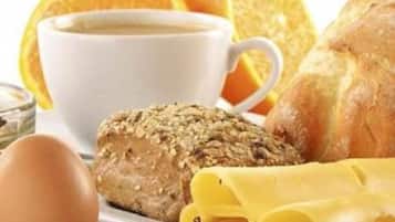 Ein Frühstückstisch mit Brot, Eiern und einer Kaffeetasse.