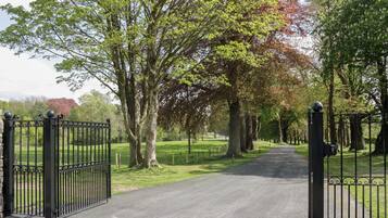 A gated entrance to a park with a paved path.
