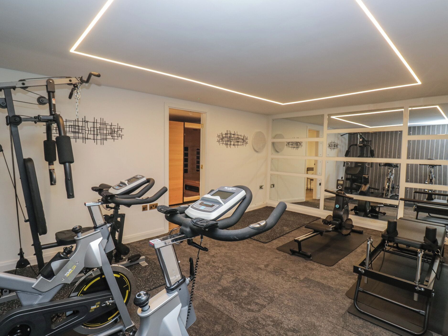 A gym with stationary bikes, a treadmill, and weight machines.