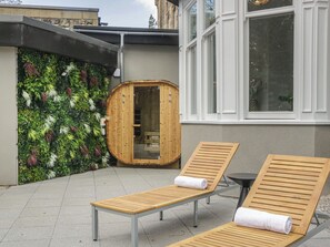 A spa area with wooden loungers, a sauna, and a green wall. - Brettargh Holt Mansion Sleeping 48 (Kendal)