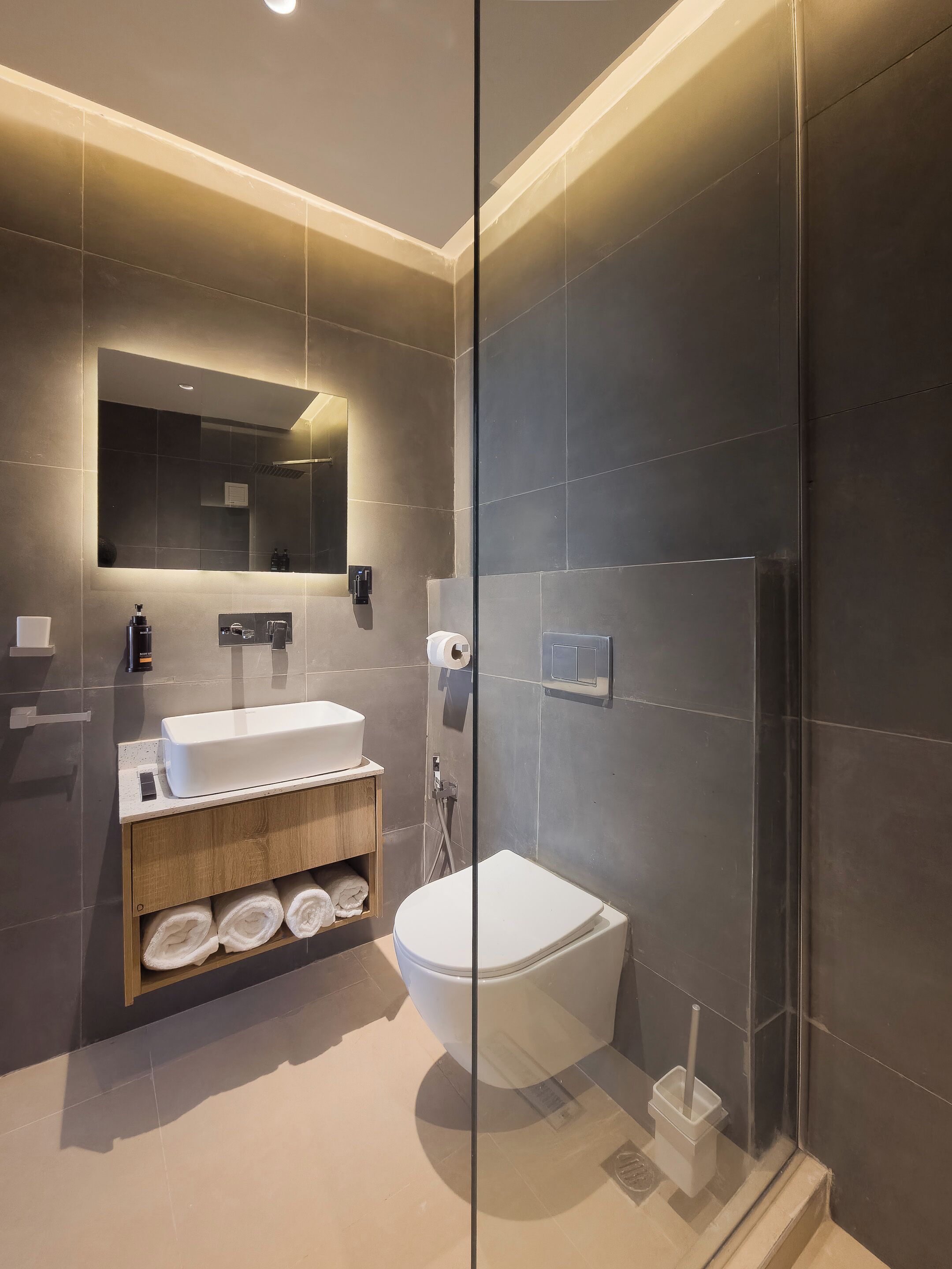A modern bathroom with a glass-enclosed shower, a white sink, and a toilet.