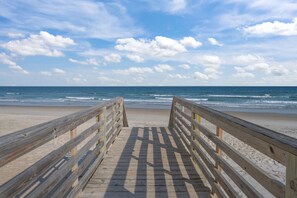 A wooden boardwalk leading to a beach with the ocean in the background. - Oceanview + Beach Access w/ Pool | Driftwood Dunes (Surf City)