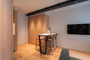 Un comedor moderno con una mesa de madera, sillas y un jarrón de flores.