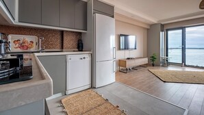 A modern kitchen with a built-in dishwasher, a large refrigerator, and a flat-screen TV. - Bosphorus View 2BR Luxury Apartment - Parking & Elevator (İstanbul)