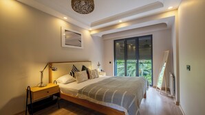 A bedroom with a bed, bedside table, lamp, and a large window with a view of greenery. - Bosphorus View 2BR Luxury Apartment - Parking & Elevator (İstanbul)