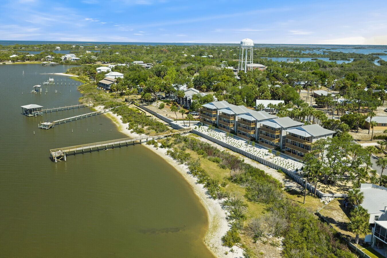 A coastal hotel with multiple buildings, a dock, and a water tower.