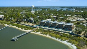 A coastal hotel with a water tower, a dock, and a beach view.