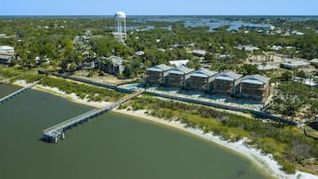 A coastal hotel with a water tower, a dock, and a beach view.