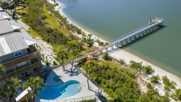 A resort with a swimming pool, a pier, and beachfront views.