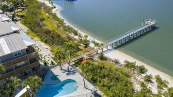 A resort with a swimming pool, a pier, and beachfront views.