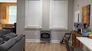 Une cuisine moderne dotée d’une cheminée intégrée, d’un ventilateur de plafond et d’un coin repas avec des tabourets de bar.