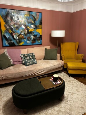 A living room with a sofa, armchair, coffee table, and a large abstract painting on the wall. - Fabulous 4-bedroom family home in tranquil Dublin neighborhood 10 mins from town (Dublin)