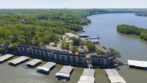 Un hotel frente al río con varias construcciones, una zona de embarque y el río.