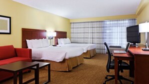 A hotel room with two beds, a desk with a computer, a TV, a red sofa, and a window with curtains. - Modern Corner 2 Rooms with 2 Double Sofabeds, Free Parking & Great Location (Houston)