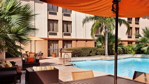 A poolside area with wicker furniture, a table, and a covered seating area. - Relaxing Houston Stay with King Bed, Sofabed & Prime Location (Houston)