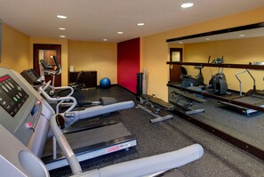 A gym with treadmills, elliptical machines, and a stationary bike.