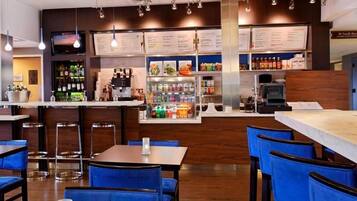 A restaurant with a bar area, seating, and a menu display.
