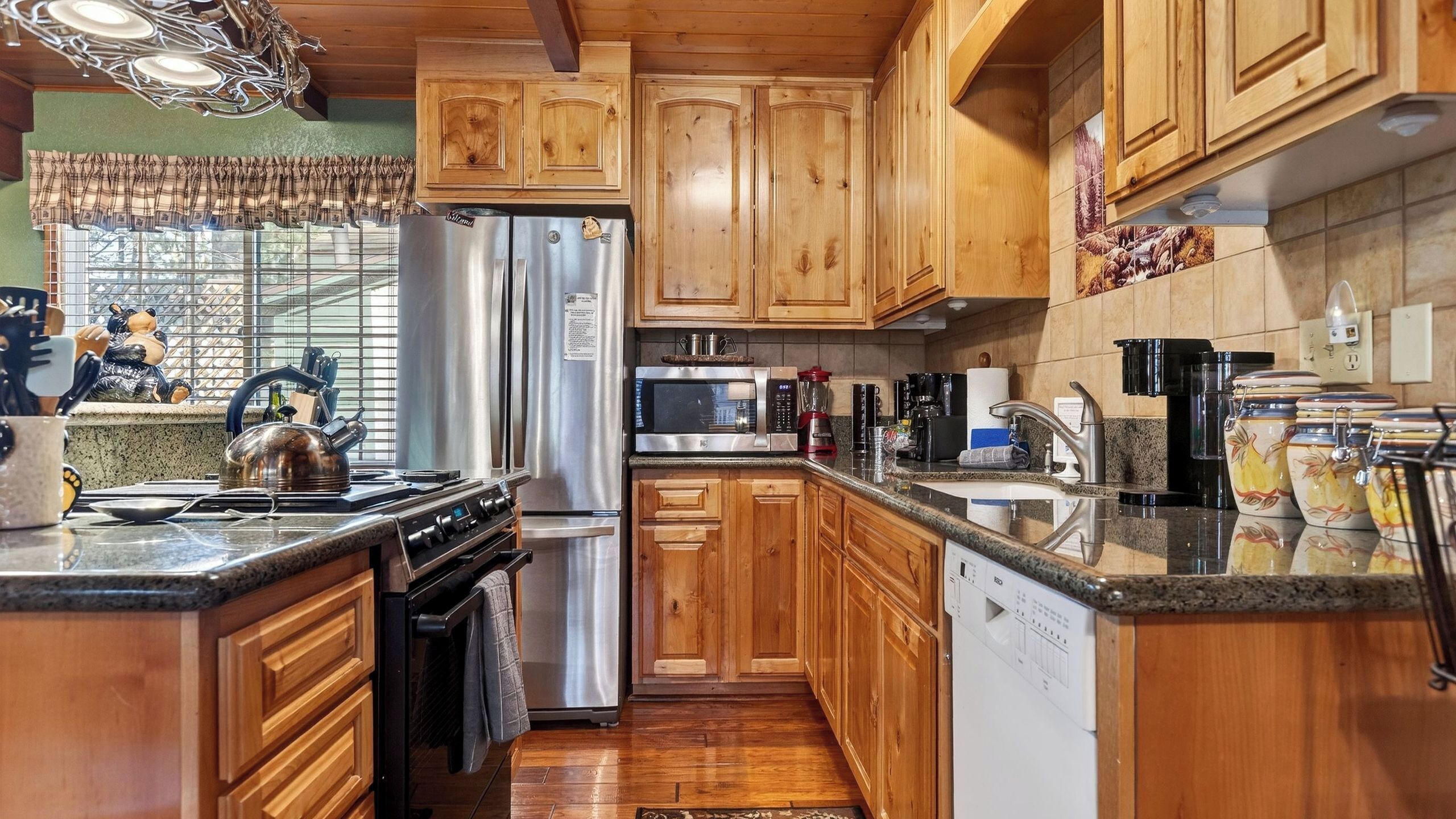 A kitchen with wooden cabinets, stainless steel appliances, and a granite countertop.