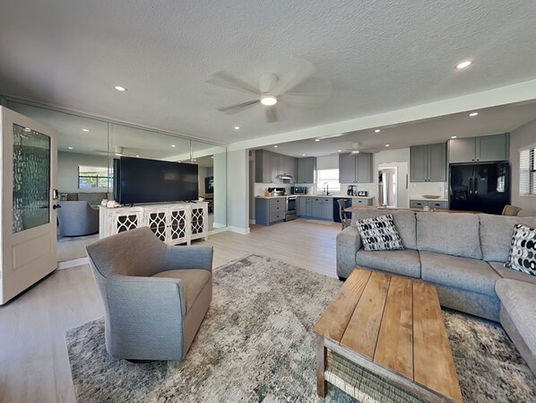 A modern living room with a sofa, coffee table, and TV. - Casa Playa Serena (St. Augustine)