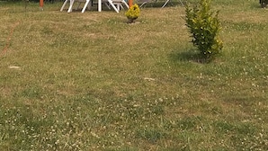 An outdoor seating area with a wooden pergola, white plastic chairs, and a small table. - La tente du Commandant PC 1954 - Unique nature experience including breakfast (Arrest)