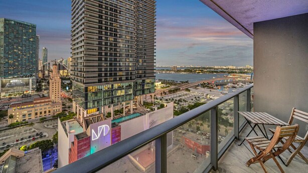 A high-rise building with a modern design, a view of a marina, and a balcony with outdoor furniture. - Casa Marina – Skyline Views Luxury Downtown Tower (Miami)