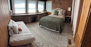A bedroom with a bed, a bench, a desk, and a window with blinds. - Cozy home Near all desirable locations; border of Lexington and Nicholasville (Nicholasville)