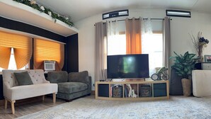 A living room with a sofa, television, and decorative items. - Cozy home Near all desirable locations; border of Lexington and Nicholasville (Nicholasville)
